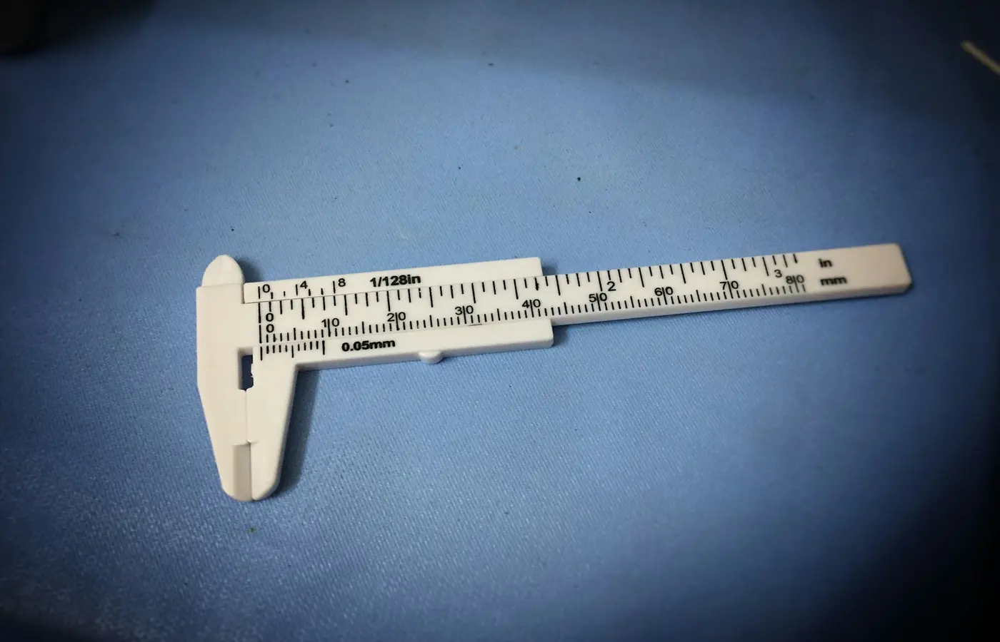 A paper caliper gauge measuring the thickness of a sheet of paper.